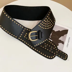Vintage leather waist belt with gold studs and a D-ring buckle on a white pedestal