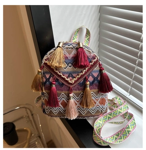 Detailed shot of ethnic woven mini backpack with colorful tassels and patterned strap