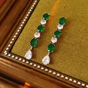 Boucles d'oreilles pendantes dorées avec émeraudes vert foncé et pompons en zircon