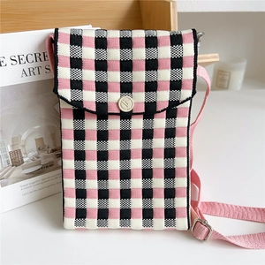 Detail of pink and black checkered knit phone bag with button flap and adjustable strap