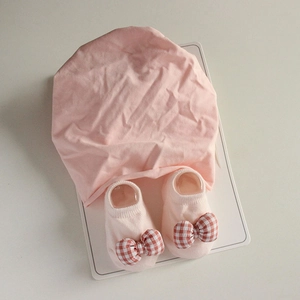 Pink newborn baby hat and sock set with checkered bow decoration in soft cotton knit