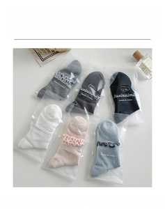 Detail view of colorful cotton mesh socks with lace cuffs in six-color pack display