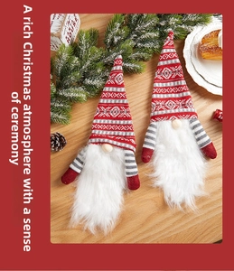 Detail of two Christmas Gnomes with knit hats and faux fur beards on a wooden table