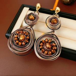 Detail view of vintage woven drop earrings with copper beads in a black jewelry box