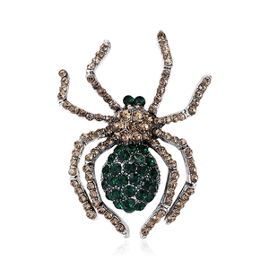 Detail of vintage spider brooch with sparkling brown and green rhinestones on metal