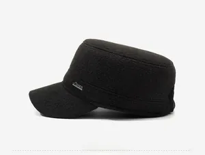 Close-up of winter flat top cap with wool texture and silver metal Sports emblem detail