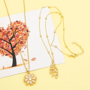 Detailed view of gold sunflower and leaf pendants with sparkling cubic zirconia crystals