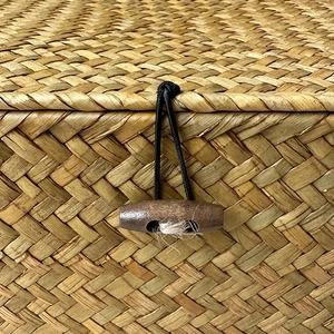 Close-up of handmade wicker gift box with wooden button closure and woven texture