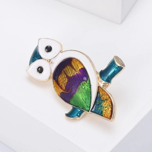 Close-up of a colorful enamel owl brooch with gold plating on a clean white background