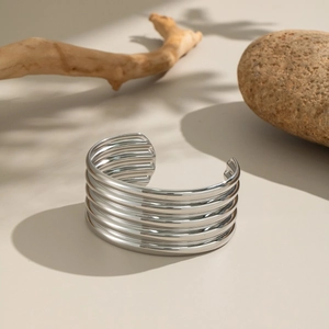 Close-up of silver wide cuff bracelet featuring unique five-layer horizontal ridges