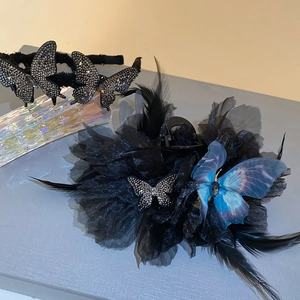 Detailed view of luxury black feather hair clip with crystal butterfly and blue accents