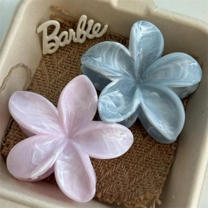 Floral frangipani hair claw clips in pastel blue and pink with marble texture