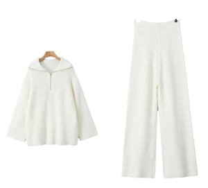 Detail of white ribbed knit two-piece set featuring half-zip collar and wide-leg trousers