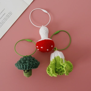 Handmade crochet set with mushroom, broccoli, and cabbage charms on pink background
