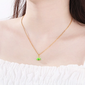 Close-up of minimalist stainless steel necklace with cherry fruit pendant on collarbone