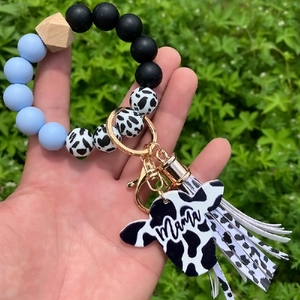 Detail of cow print beads and Mama cow head charm on leopard silicone keychain bracelet