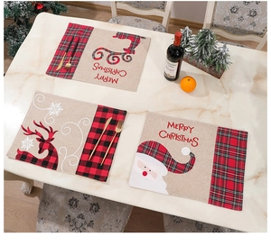 Detail of Christmas burlap placemats with Santa Claus and reindeer on marble table