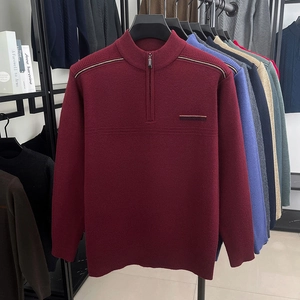 Detail of burgundy men's knit sweater featuring a half-zip stand collar and ribbed texture