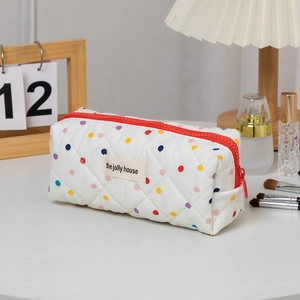 Detailed macro view of a quilted colorful polka dot pencil case with a vibrant red zipper