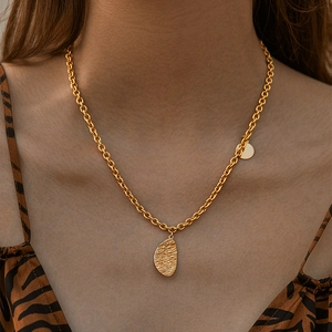 Chic 18K gold O-chain necklace with textured semi-oval pendant on tiger print background