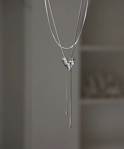 Detailed close-up of liquid metal silver irregular heart pendant with snake bone chain