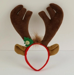 Detail of plush reindeer antlers headband with a golden bell and green holly leaf decor
