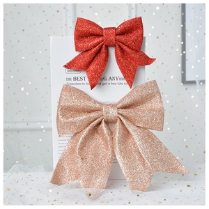 Detail view of large sequined bows in red and gold for Christmas tree and gift decoration
