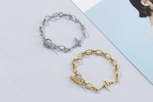 Detail of metal link bracelet with heartbeat lifeline charm and toggle OT clasp closure