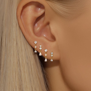 Close-up of S925 silver gold-plated earring set with sparkling zircon on a woman's ear