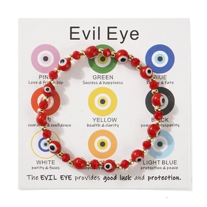 Λεπτομέρεια από κόκκινο βραχιόλι Evil Eye με χρυσές λεπτομέρειες σε λευκή κάρτα