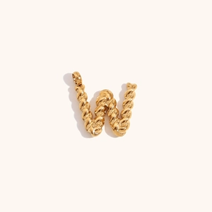 Detailed view of an 18K gold-plated twisted texture letter W pendant on beige background