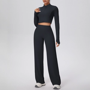 Détail de l'ensemble de yoga noir avec pantalon large et veste de sport à fermeture