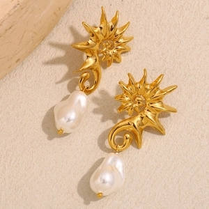 Détail macro de boucles d'oreilles hippocampe plaquées or 18 carats et perles baroques