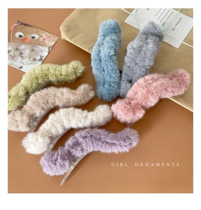 Close-up of wavy plush hair claws in seven colors including mint and lilac for winter hair
