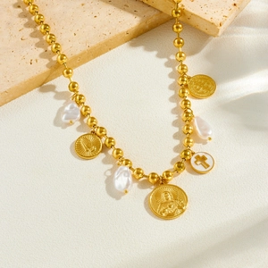 Vintage gold pearl necklace with religious cross medals and white shell portrait charms