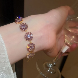 Detailed view of 18k gold plated bracelet featuring sparkling purple zircon flower charms