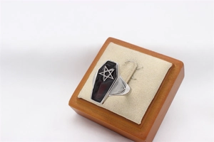 Macro view of gothic coffin-shaped ring face with black enamel and silver star detail