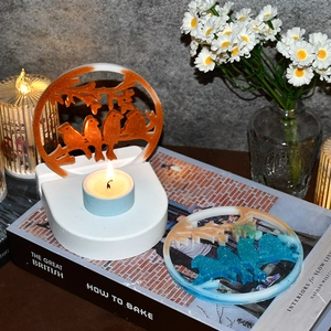 Creative resin bird candle holder set with orange glitter and lit blue tea light