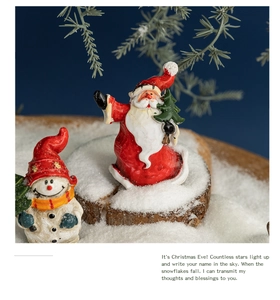 Detailed view of Santa and snowman figurines on a snow-covered wooden base