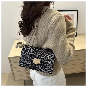 Elegante Umhängetasche mit Leopardenmuster und Goldkette am Modell in Innenräumen gezeigt