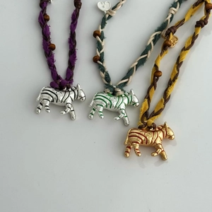 Détail du collier pendentif zèbre avec corde en coton tissé et perles de bois sur blanc