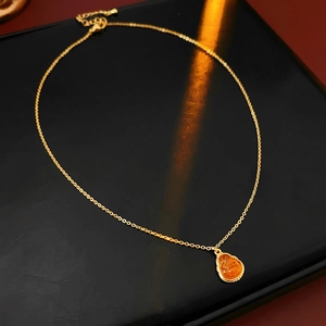 Detail of gold-plated Buddha pendant on elegant chain with light reflection