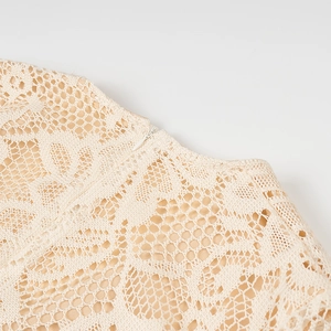 Dettaglio ravvicinato del pizzo beige e della cerniera invisibile sull'abito lungo