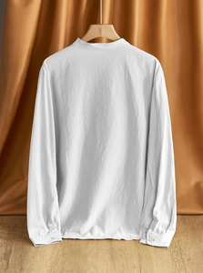 Detail shot of white linen shirt fabric showing breathable cotton texture and mandarin collar