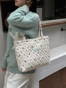 Close-up of quilted cotton tote bag featuring cute bear prints and a brand fabric label