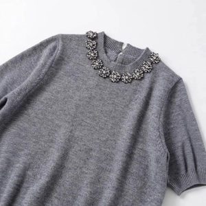 Pull en maille grise à manches courtes avec col orné de perles en cristal brillant