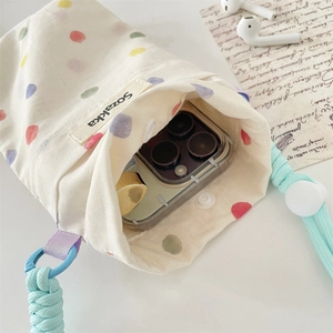 Dettaglio della borsa porta cellulare in tela a pois colorati con coulisse e tracolla