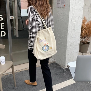 Photo de rue d'un sac cabas en velours côtelé crème avec broderie d'œuf mignon