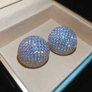 Vue macro des boucles d'oreilles sphériques pavées de cristaux dans un coffret