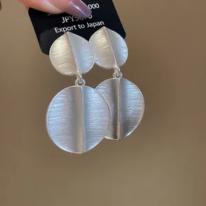 Matte silver geometric hoop earrings with brushed texture and layered circle pendant